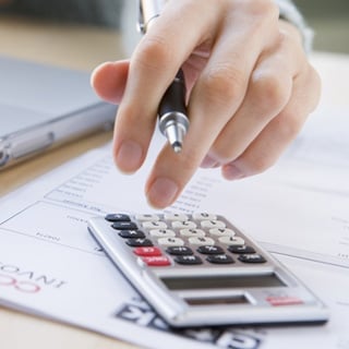 Calculator with an invoice in the background